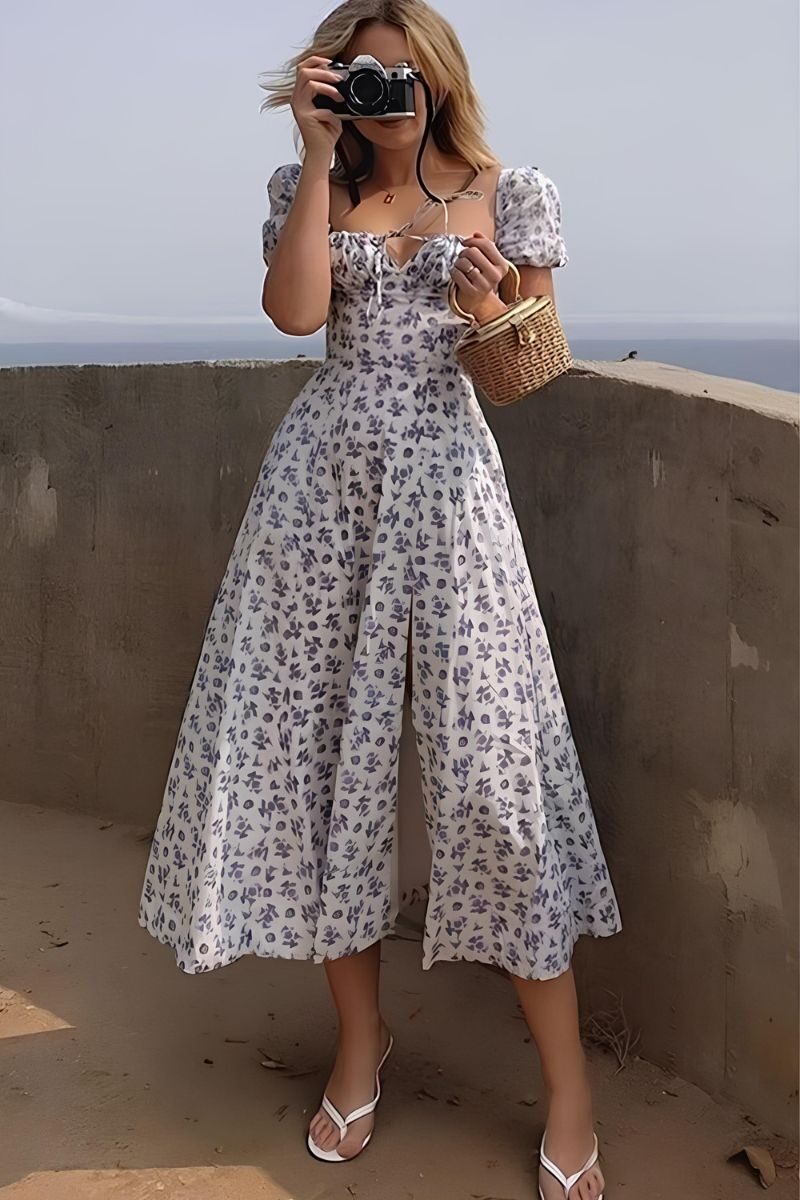 Femme en robe bohème à fleur, dos nu, prenant une photo